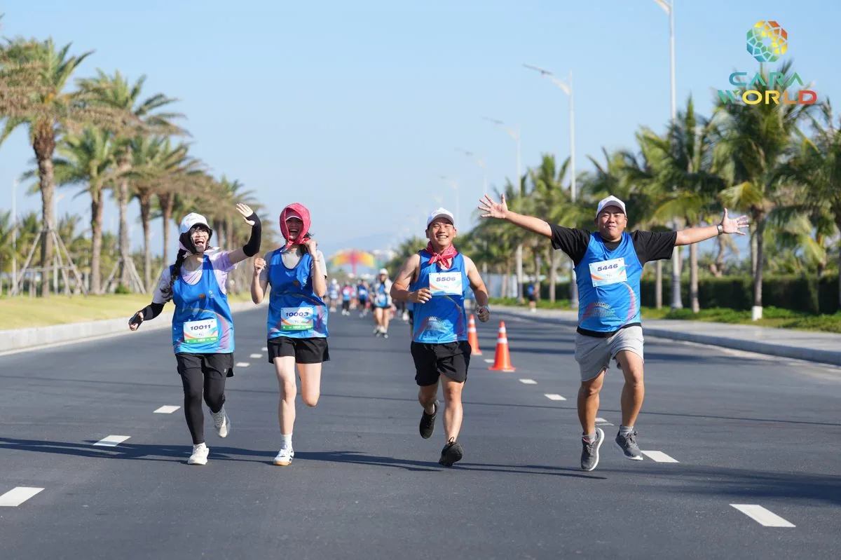 Bốn vận động vi&ecirc;n vui vẻ nắm tay chạy tr&ecirc;n đại lộ ven biển CaraWorld giải Cara Run 2026