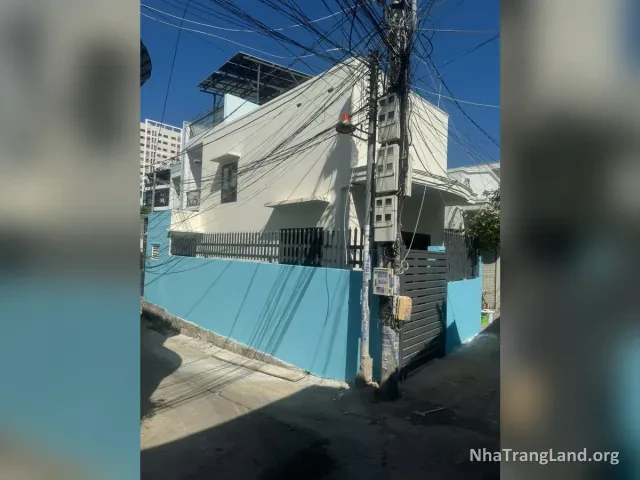 Nhà căn góc sơn trắng, tường rào xanh nhìn từ hẻm