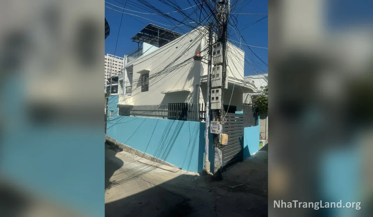 Nhà căn góc sơn trắng, tường rào xanh nhìn từ hẻm