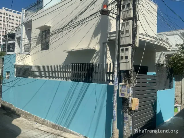 Nhà căn góc sơn trắng, tường rào xanh nhìn từ hẻm — ảnh 2