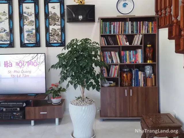 Phòng khách có kệ sách, tivi và cầu thang gỗ lim — ảnh 3