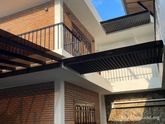 Mặt ngoài villa 2 tầng tường gạch thẻ, có ban công — ảnh 3