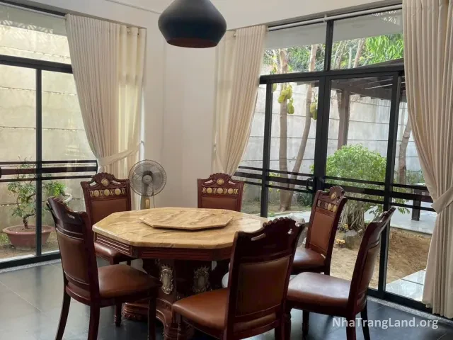 Bàn ăn gỗ cạnh cửa kính nhìn ra vườn — ảnh 6