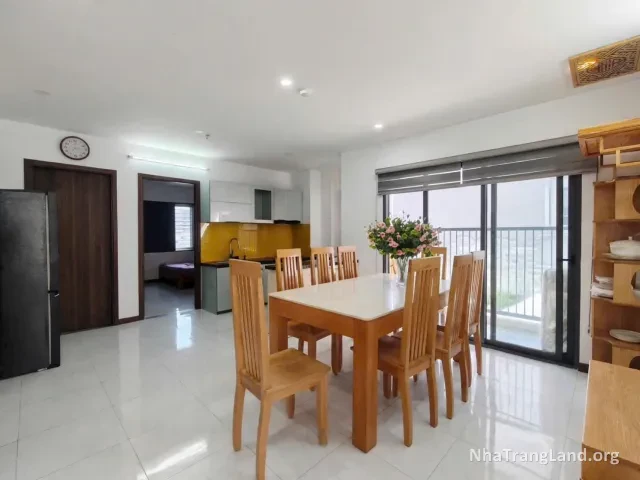 Phòng khách có tủ lạnh, bàn ăn và cửa kính ra ban công — ảnh 3