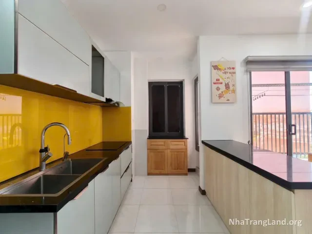 Khu bếp với tủ bếp kính vàng và bồn rửa — ảnh 4
