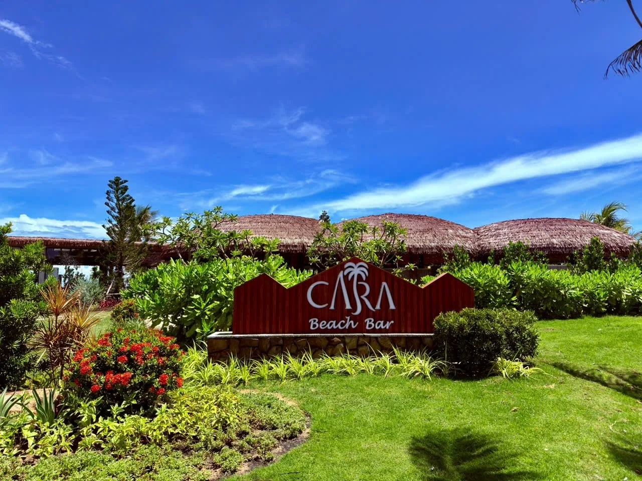 Biển gỗ nhận diện CARA Beach Bar mộc mạc bên bãi cát trắng Bãi Dài