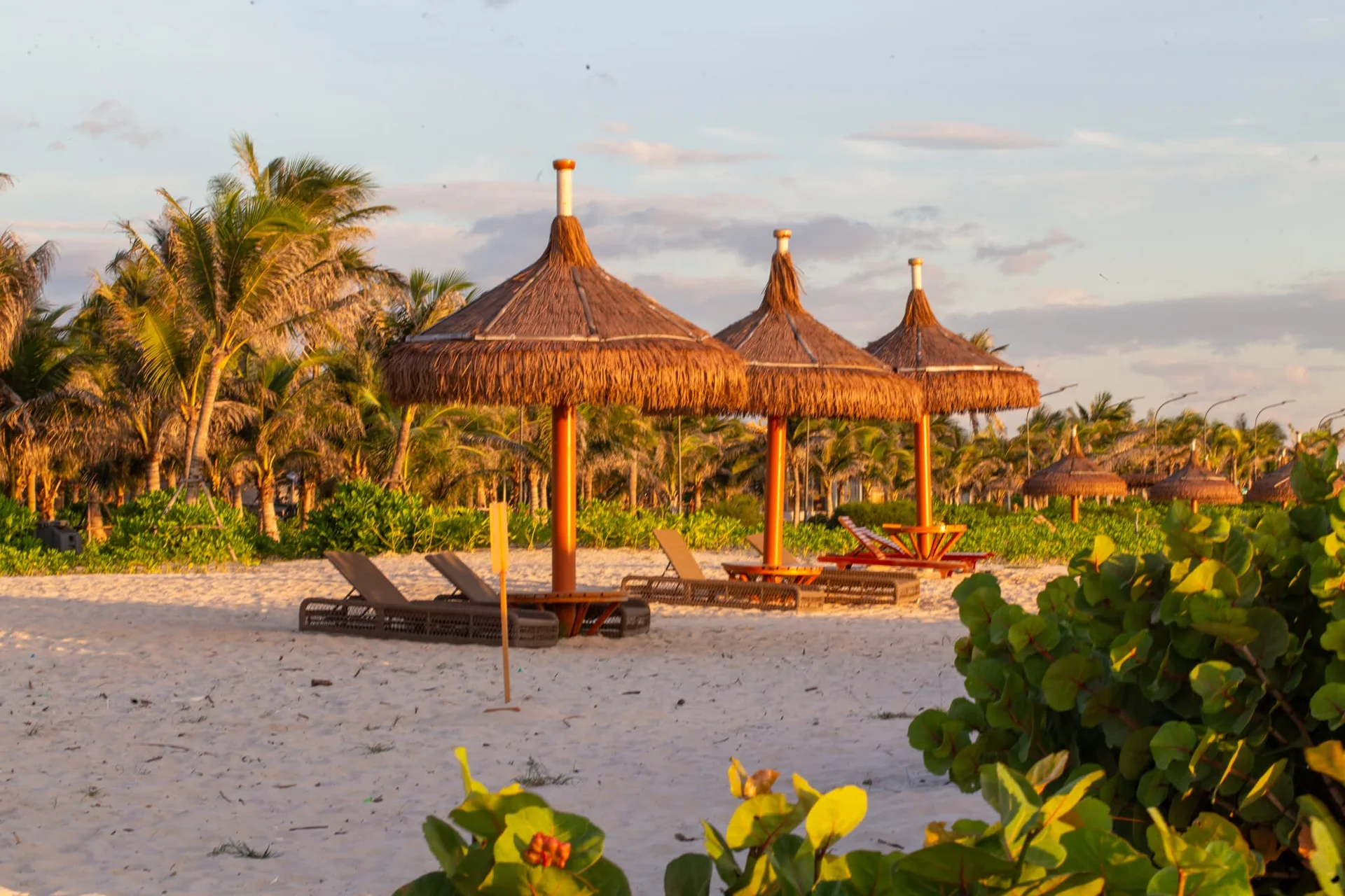 D&atilde;y ch&ograve;i nghỉ m&aacute;i l&aacute; cabana v&agrave; ghế tắm nắng đ&oacute;n ho&agrave;ng h&ocirc;n ngay m&eacute;p c&aacute;t CaraBeach
