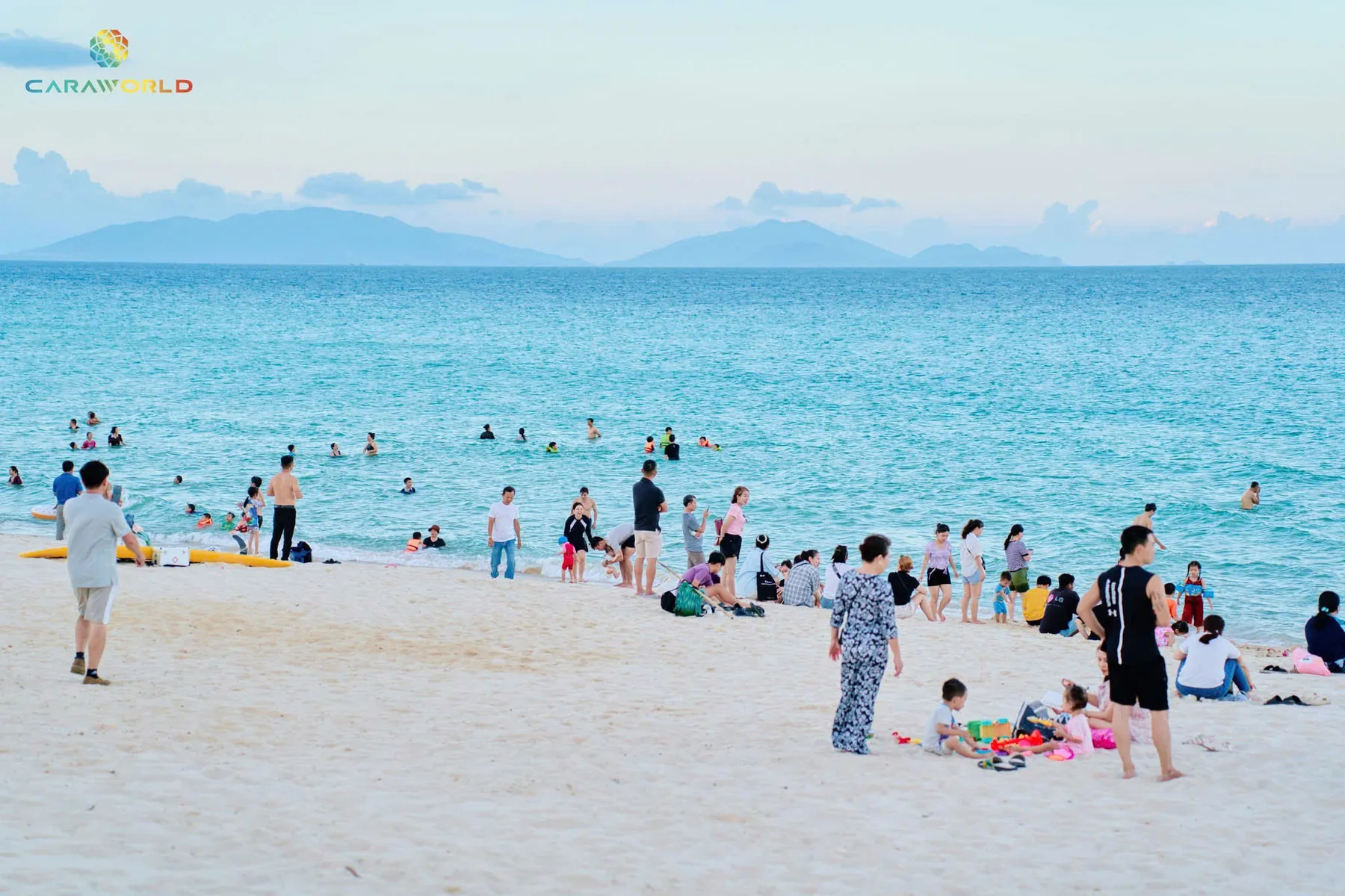 Gia đình và du khách tắm biển, chèo ván SUP trên làn nước trong vắt tại CaraBeach Bãi Dài