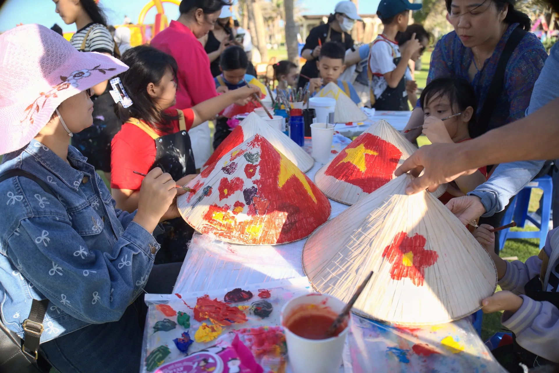 Trẻ em v&agrave; phụ huynh h&agrave;o hứng tham gia hoạt động vẽ n&oacute;n l&aacute; truyền thống tại lễ hội biển CaraBeach