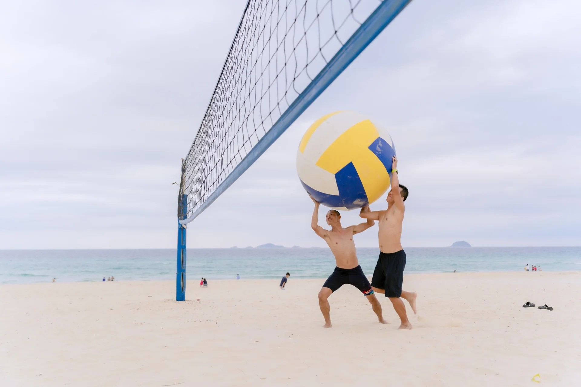 Du kh&aacute;ch h&agrave;o hứng thi đấu b&oacute;ng chuyền b&atilde;i biển s&aacute;t m&eacute;p s&oacute;ng tại C&ocirc;ng vi&ecirc;n biển CaraBeach