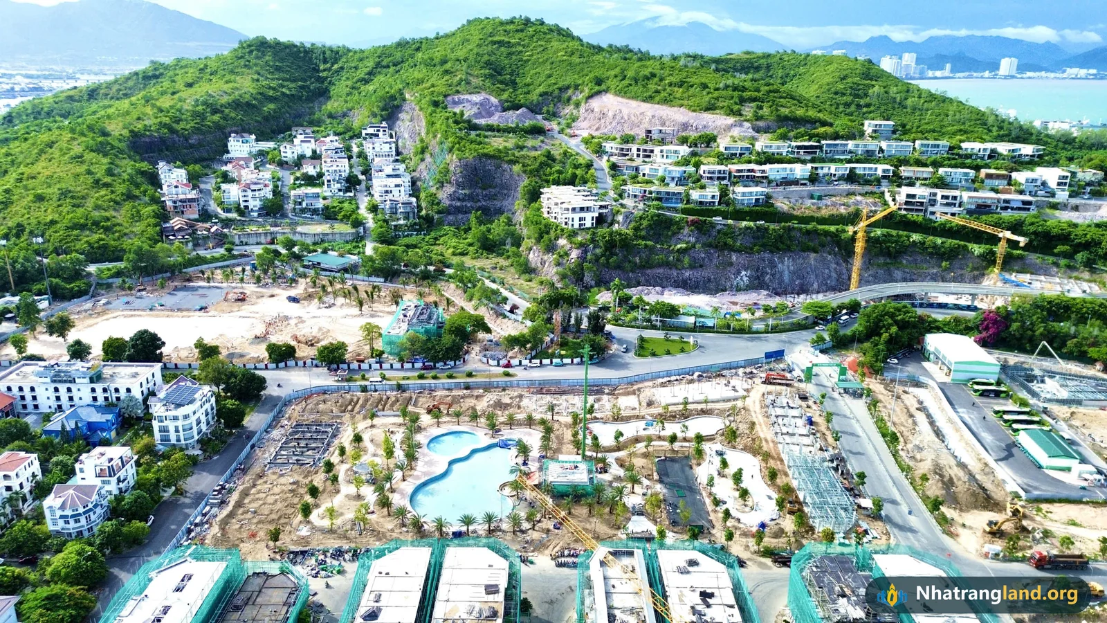 Ảnh flycam thực tế tháng 10/2026 hồ bơi Resort ngoài trời rộng hơn 1.000 m² đã tích nước xanh biếc tại Công viên trung tâm 0,68 ha Vinhomes Pearl Bay