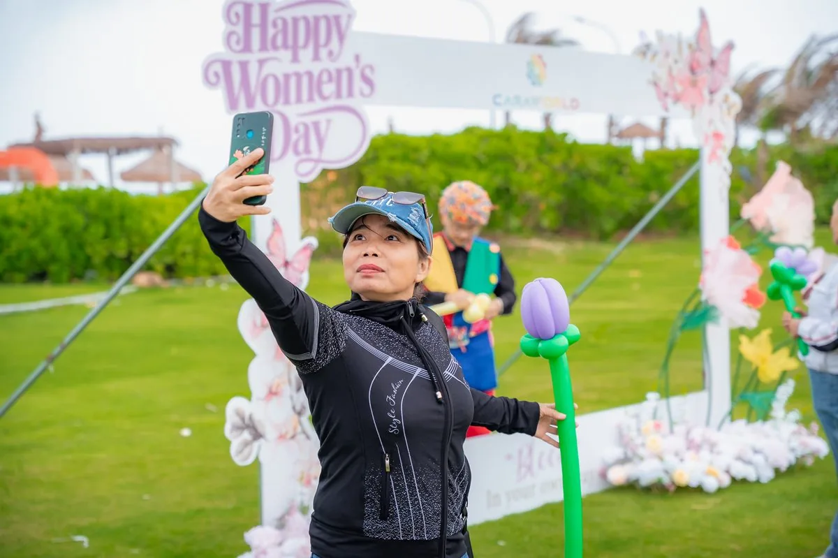 Phụ nữ selfie check-in tại photo frame Happy Women Day trang trí hoa bướm CaraWorld