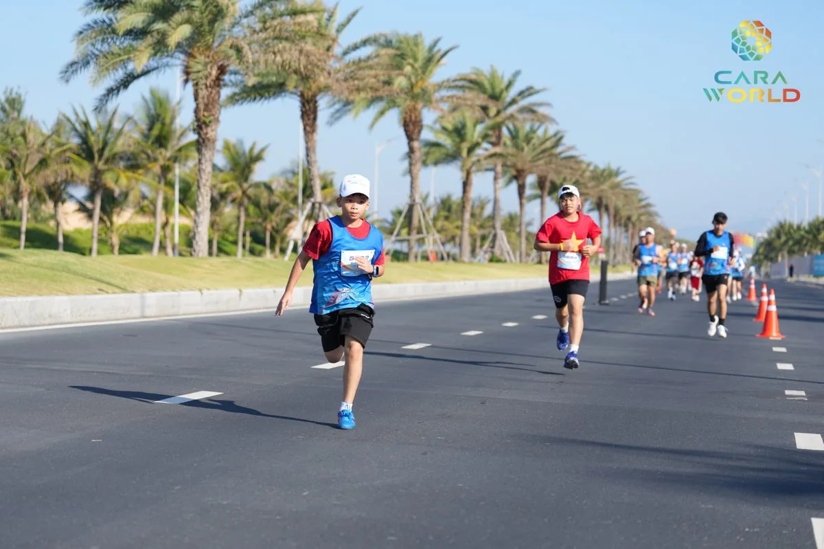 Vận động viên nhí và người lớn chạy trên đại lộ hàng cọ dừa ven biển CaraWorld Cara Run 2026