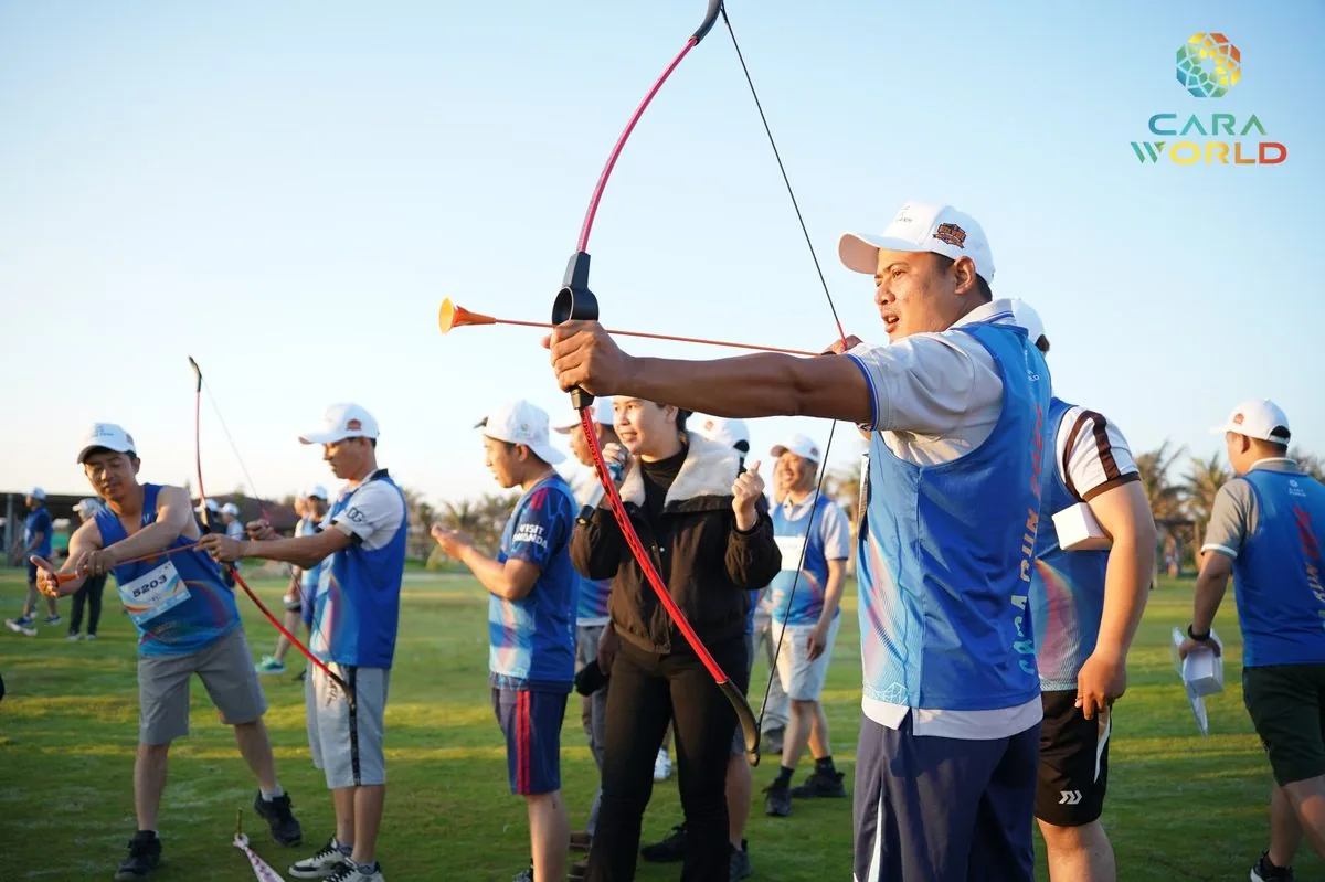 Vận động viên chơi bắn cung trên thảm cỏ xanh hoạt động team building Cara Run 2026 CaraWorld