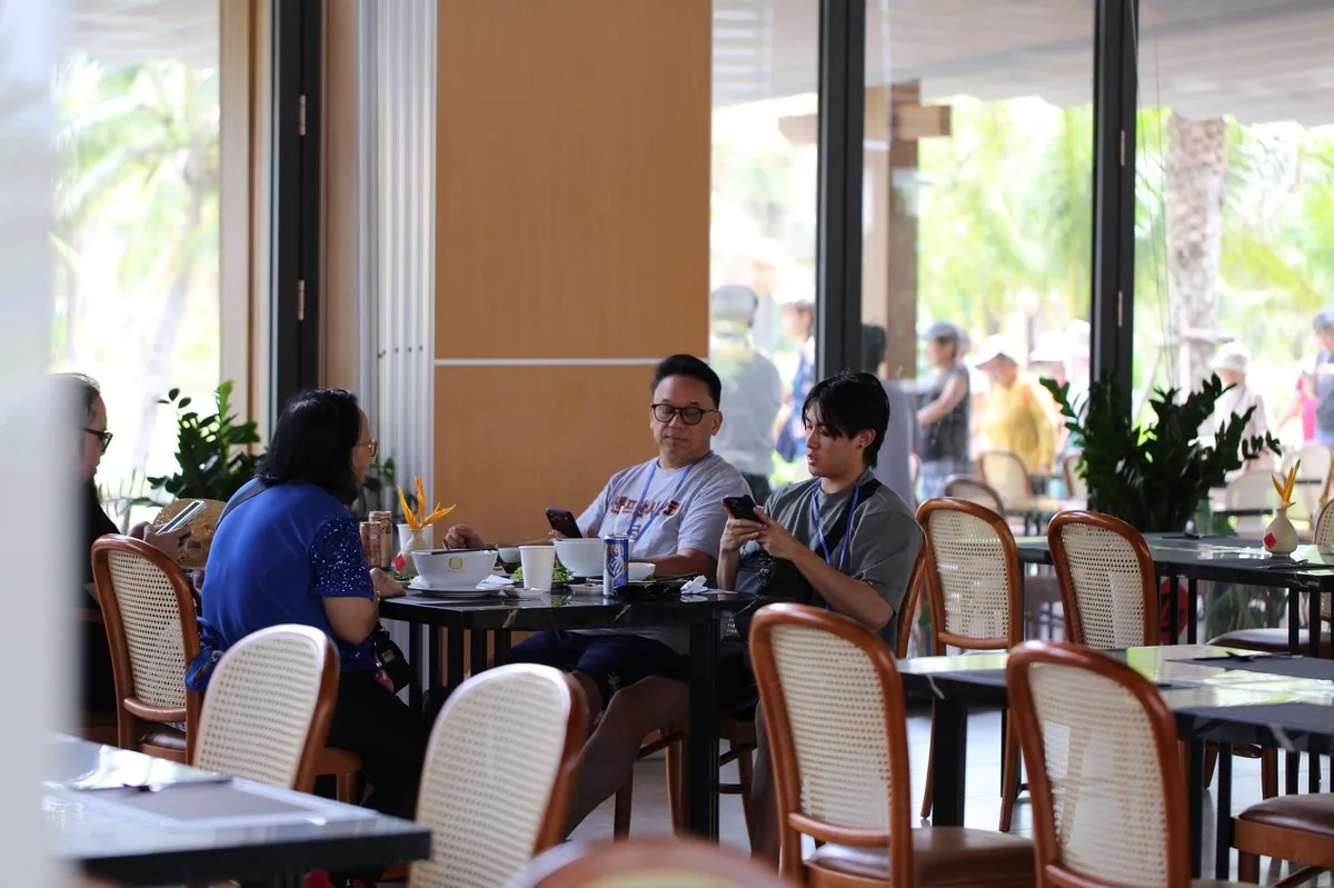 Du khách thưởng thức cà phê tại nhà hàng ngoài trời CaraWorld Cam Ranh sau chuyến tham quan